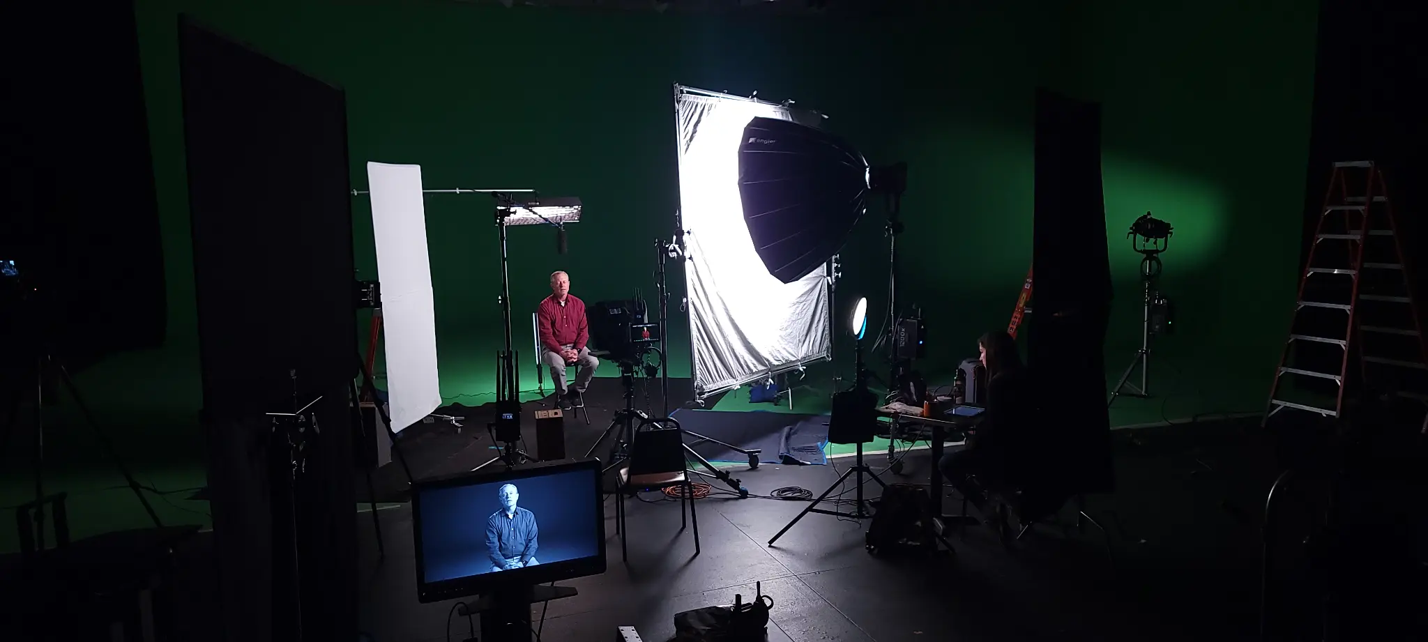 Video crew setting up lighting for executive interview